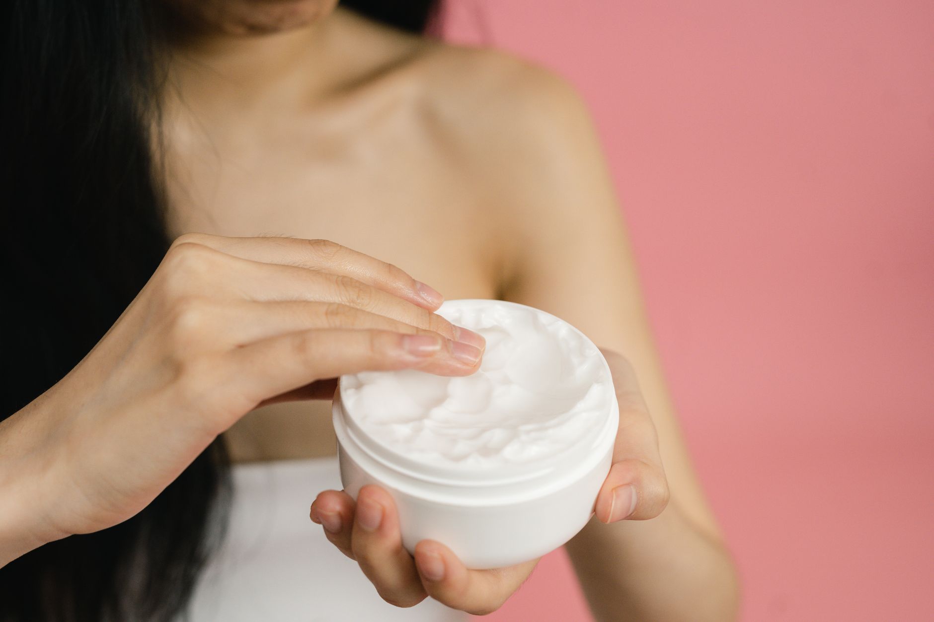Notre avis détaillé sur la Curl Defining Cream de Moroccanoil pour cheveux bouclés — femme appliquant crème définissante boucles